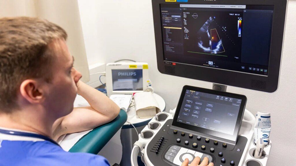 Cardiac Amyloidosis Diagnosis Gets a More Extensive AI Model A photo of a male cardiologist during echocardiography of his male patient.
