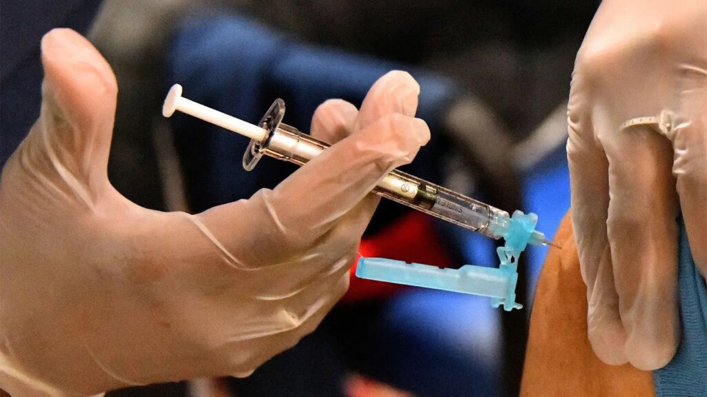 A photo of a healthcare worker administering a COVID vaccine shot.