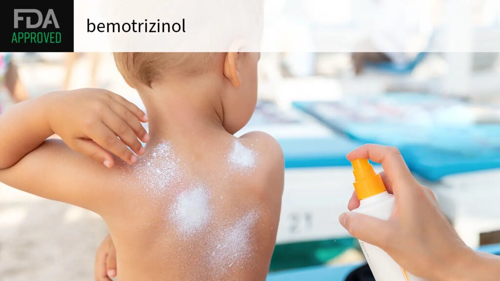 FDA APPROVED bemotrizinol over a photo of a mother applying sunscreen to her toddler son’s back.