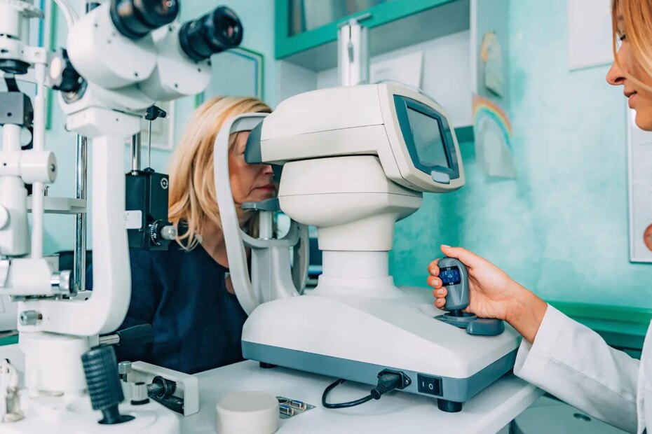 A photo of a female ophthalmologist examining her mature female patient’s eye.