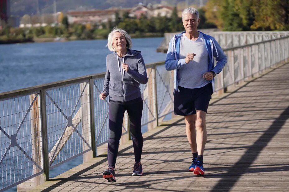 A photo of a senior couple walking across a foot bridge.