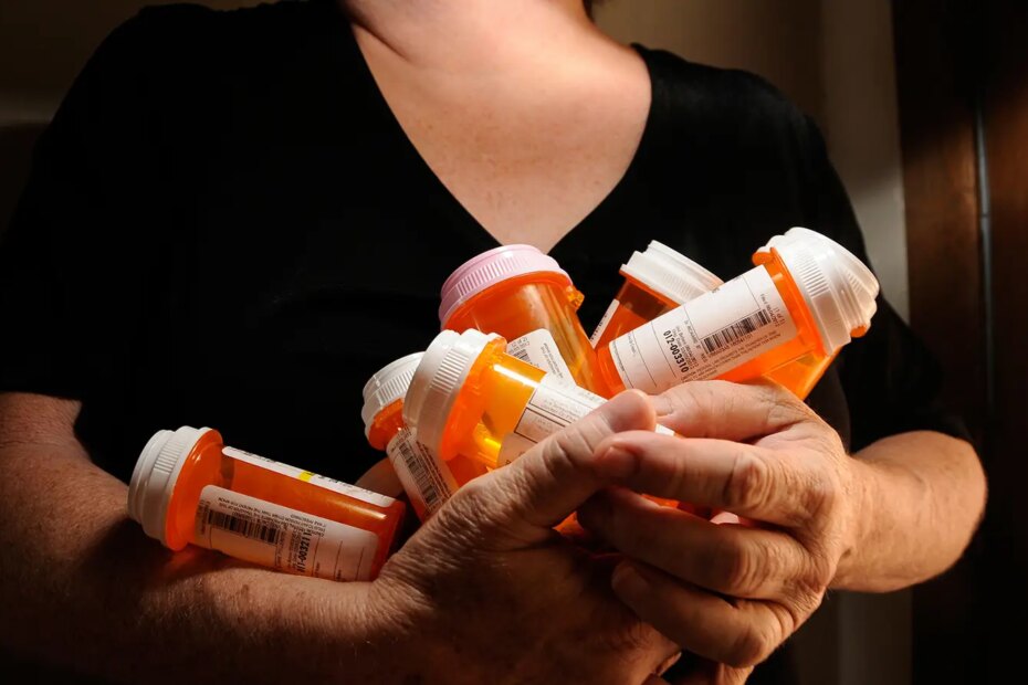 A photo of a woman carrying an armload of prescription medication bottles.