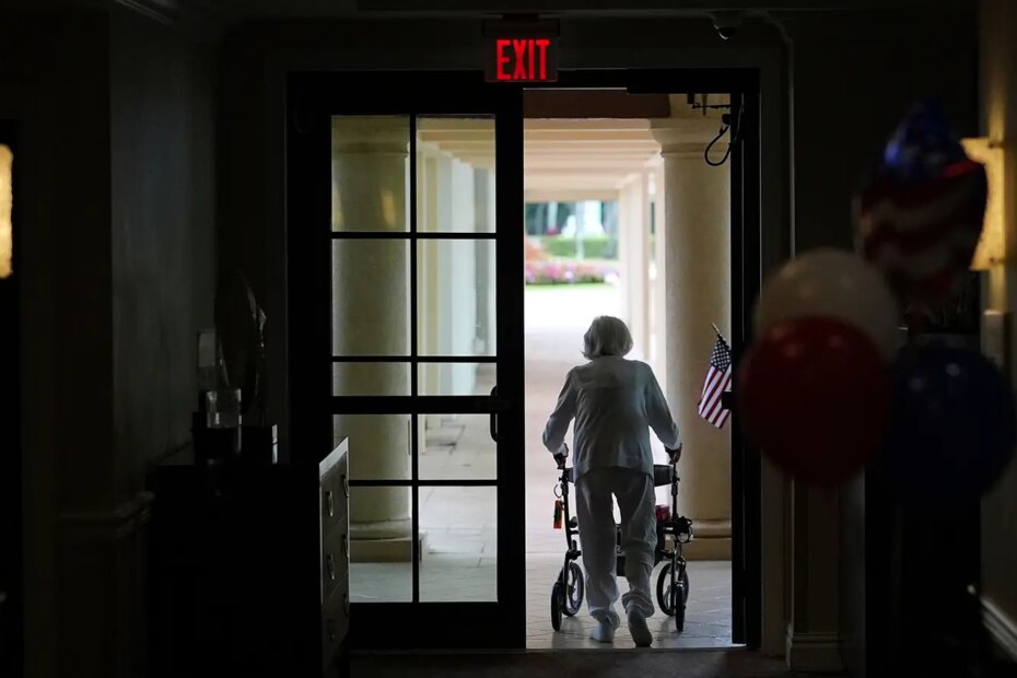 A photo of a woman using a walker as she exits an assisted living building in Boca Raton, Florida.