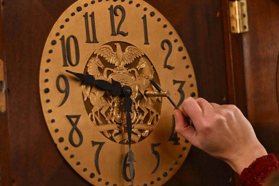 A photo of Bethany Gill winding a clock in the Pennsylvania Supreme Court chamber in Harrisburg, Pennsylvania.