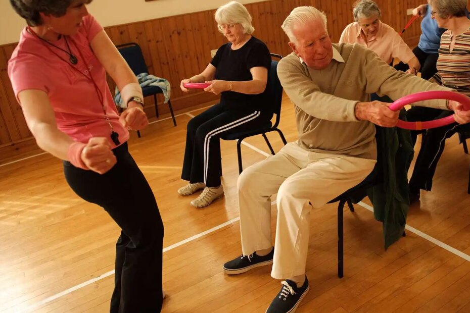 A group of senior citizens participating in low-impact chair aerobics.