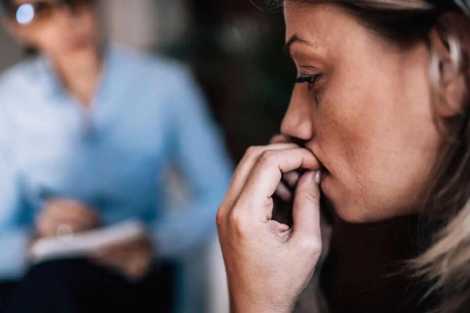 Woman with anxiety talking to mental health professional.