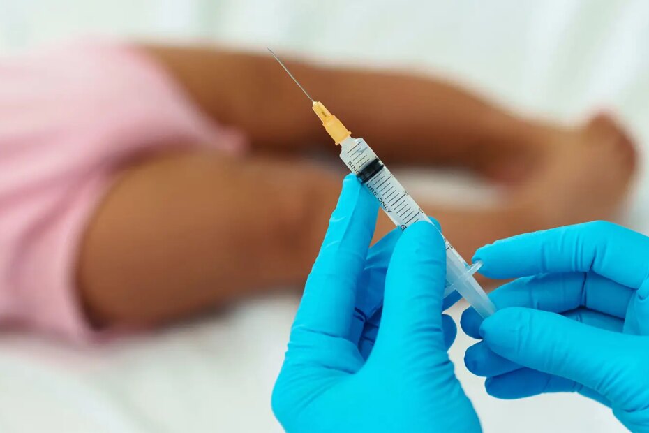A photo of a female physician preparing to vaccinate a toddler.