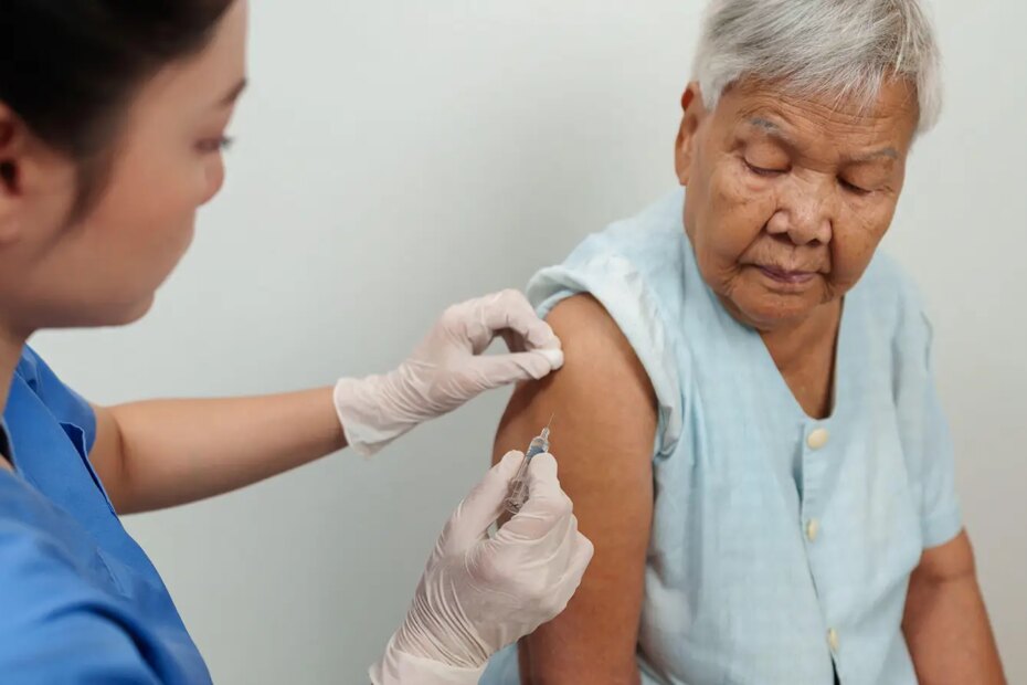 A photo of a young female nurse vaccinating a senior woman.