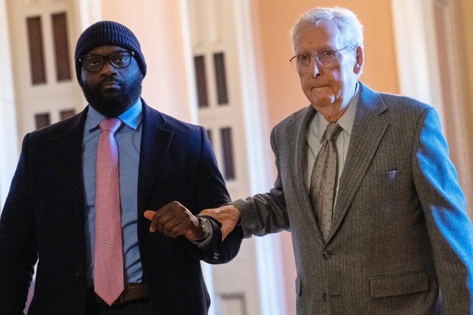 A photo of Sen. Mitch McConnell receiving assistance as he walks through the Capitol, Jan. 15, 2026, in Washington.