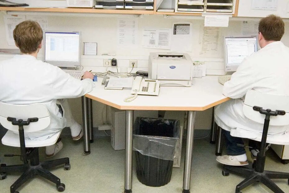 Two doctors working in a shared office space.