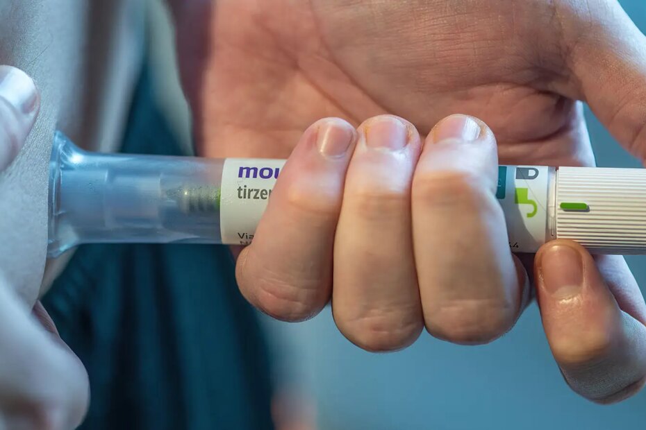 A photo of a man self-injecting his abdomen with a tirzepatide injection pen.