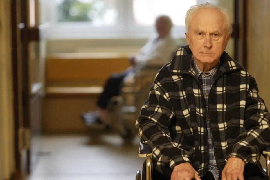 A photo of a senior man in a wheelchair of an assisted living facility.