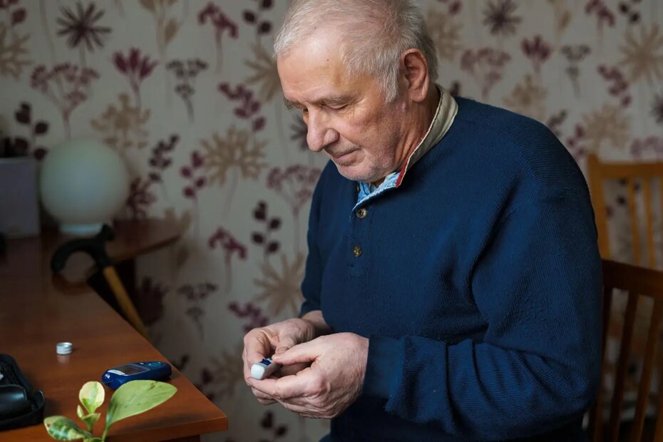 A photo of a senior man holding a lancet device.
