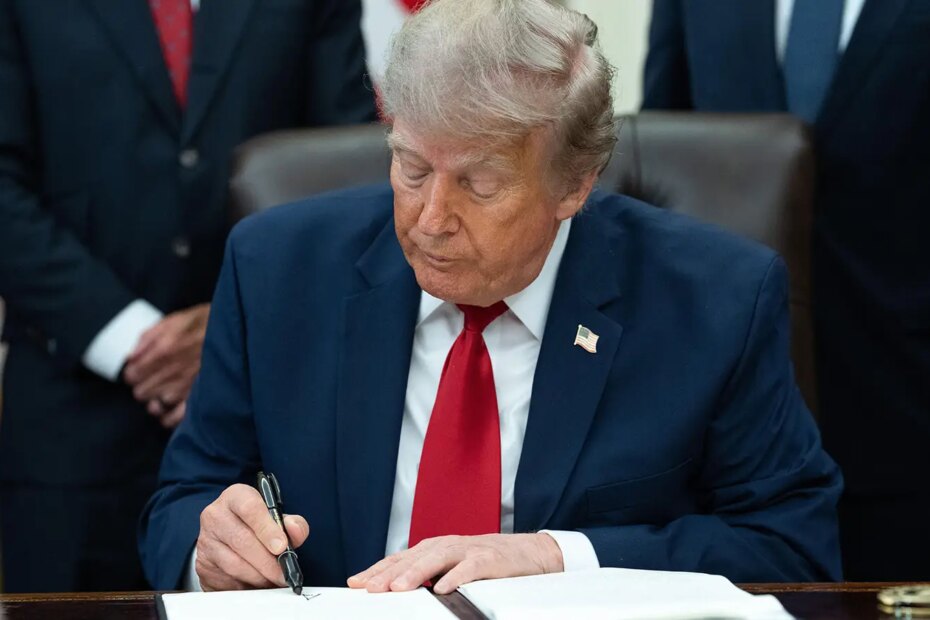 A photo of Trump signing an Executive Order in the Oval Office.