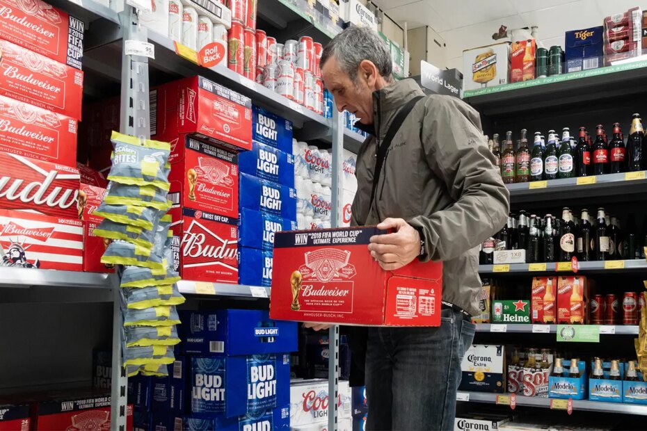 A photo of a mature man buying a case of Budweiser beer.